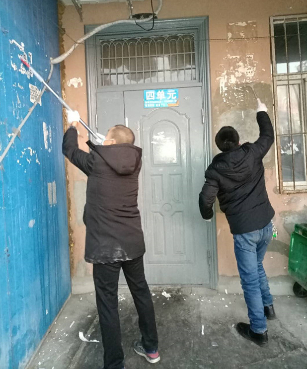 1612254845113516.jpg 圖為:物業(yè)公司員工清理小廣告現(xiàn)場_副本.jpg